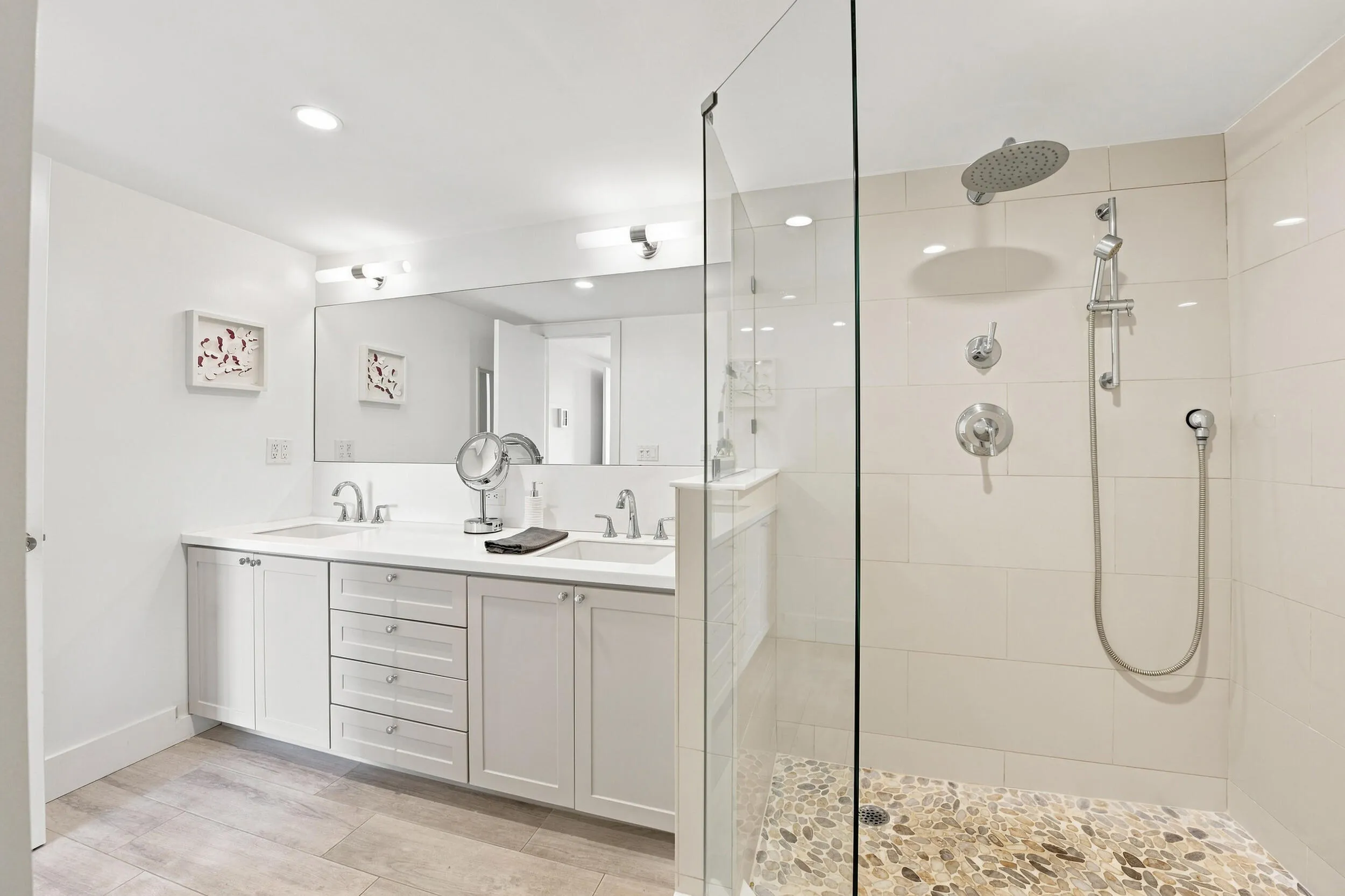 Spacious walk-in shower with a pebble floor and rainfall showerhead