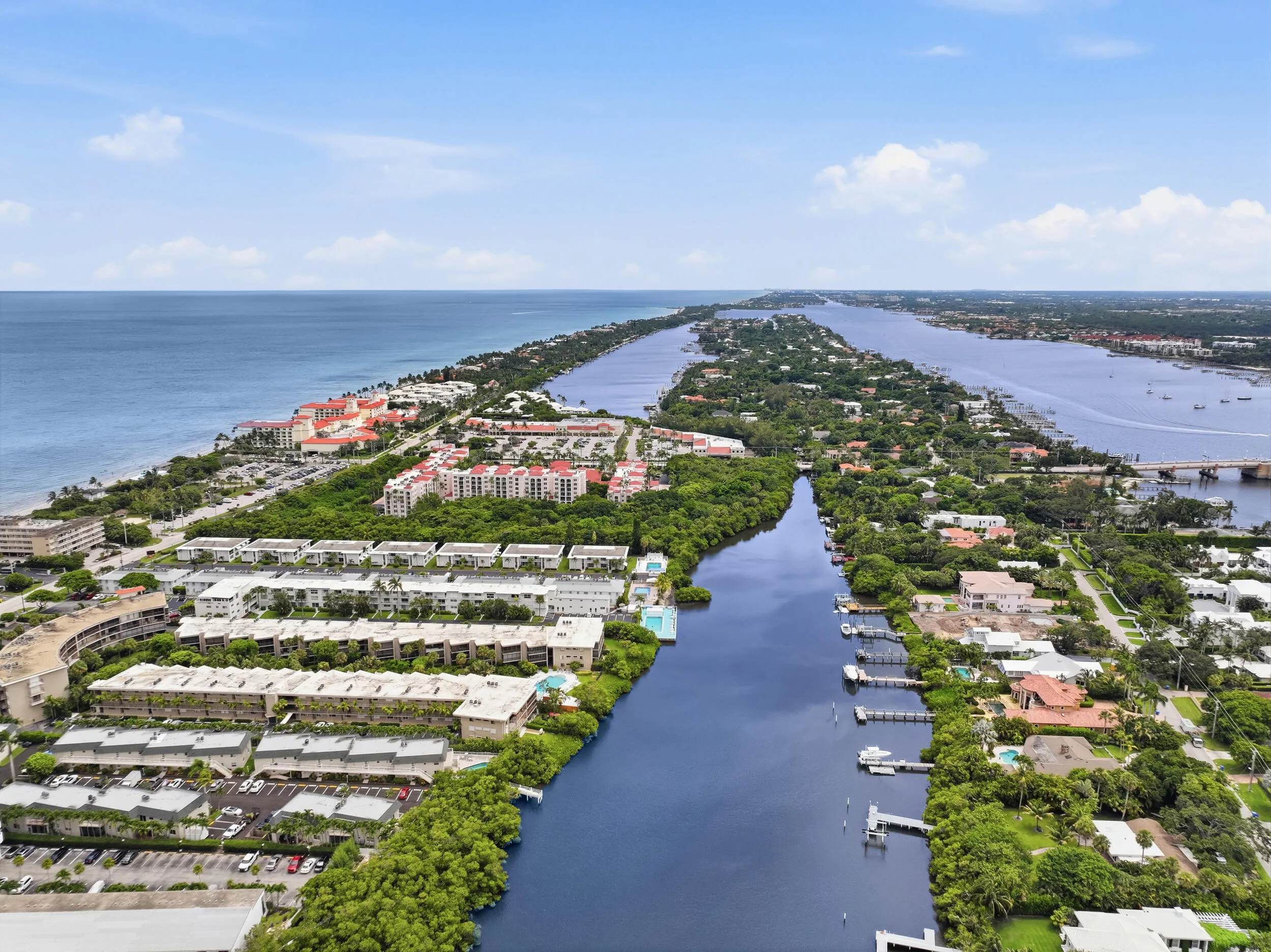 Aerial perspective showcasing waterfront properties along a canal and expansive oceanfront