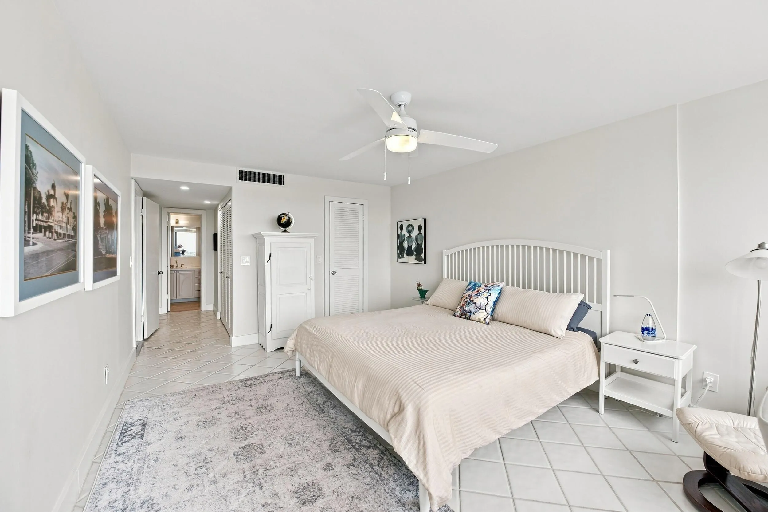 Very Spacious Primary Neutral-toned bedroom featuring white tile flooring and a ceiling fan with integrated lighting