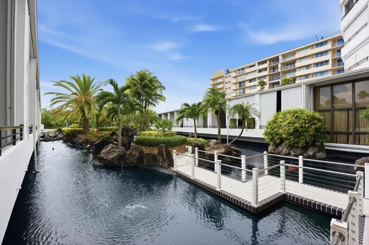 Tranquil water feature with a stone island and lush tropical plantings