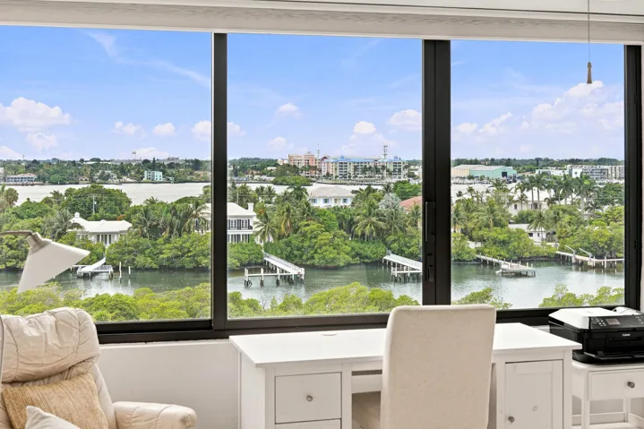 Floor-to-ceiling windows framing expansive water and city views
