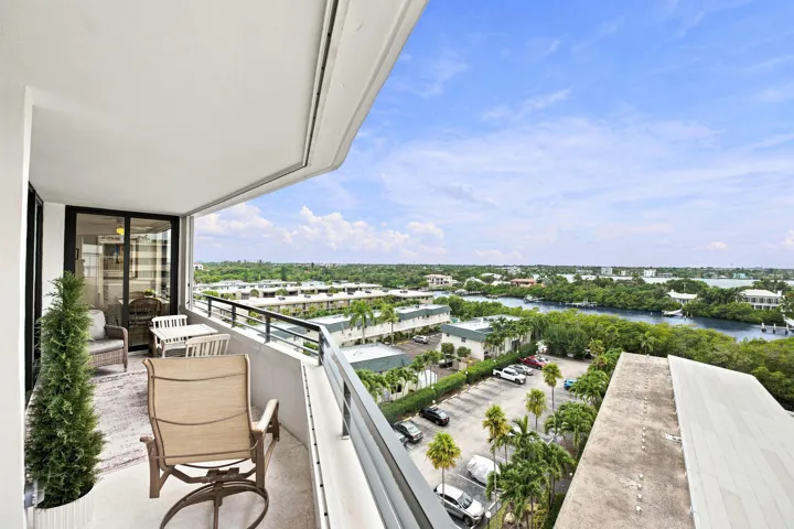 Spacious balcony featuring a curved architectural design, concrete flooring, and a black metal railing