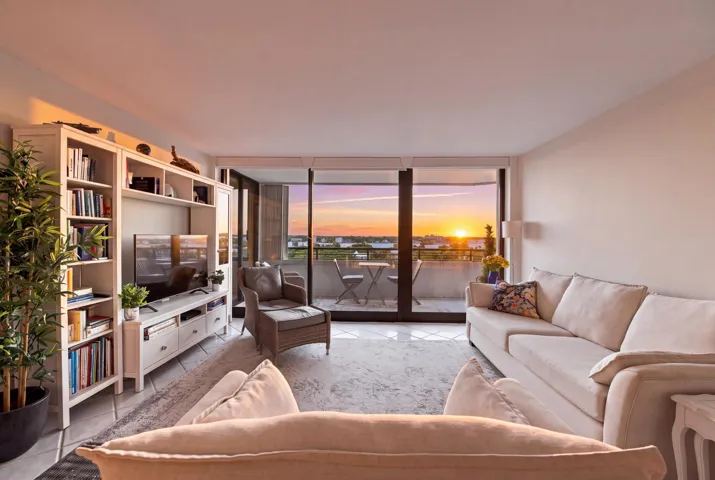 Spacious living area featuring floor-to-ceiling sliding glass doors opening to a private balcony