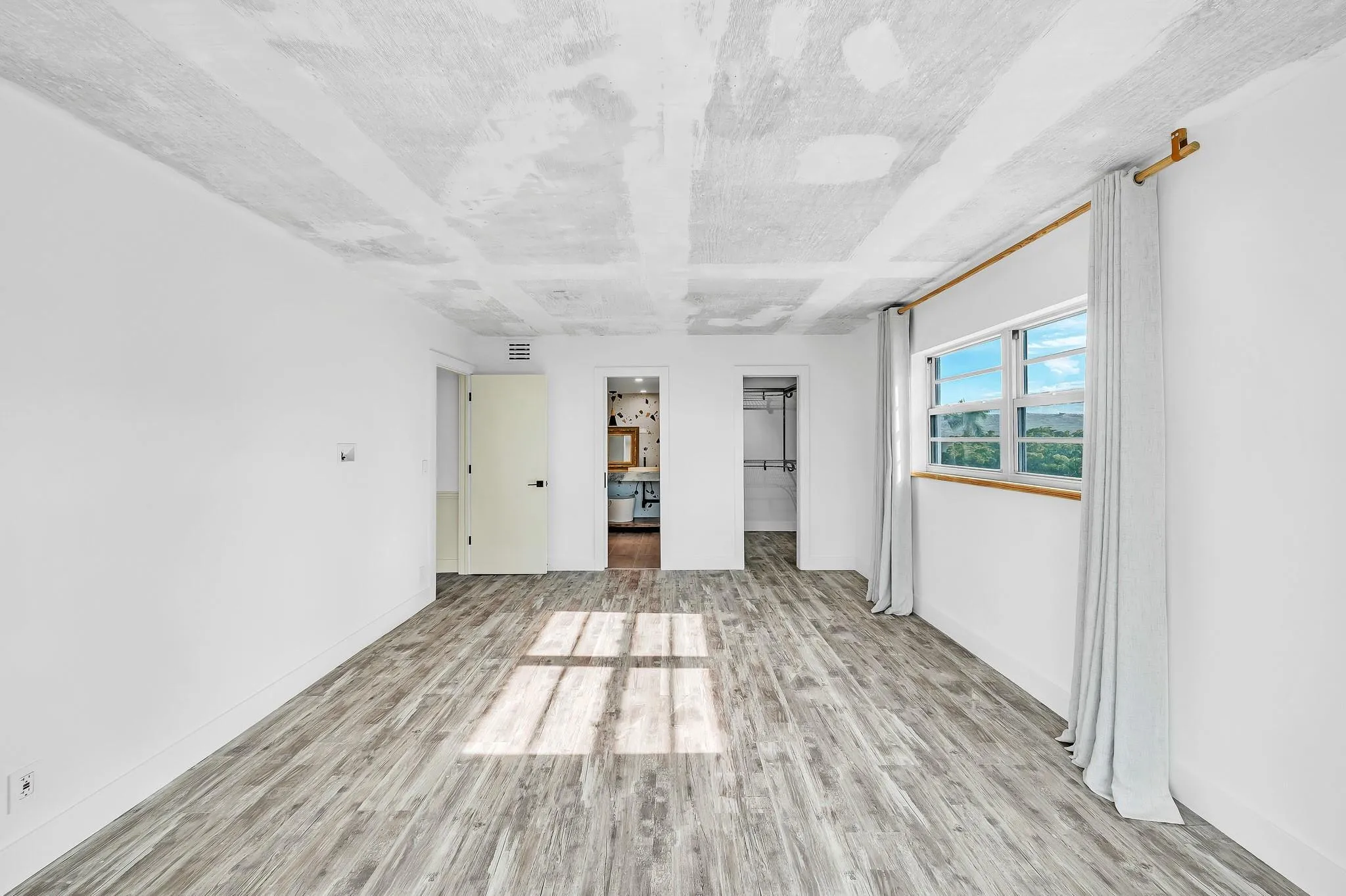Wood-finish flooring, white walls, and a window with a wood sill