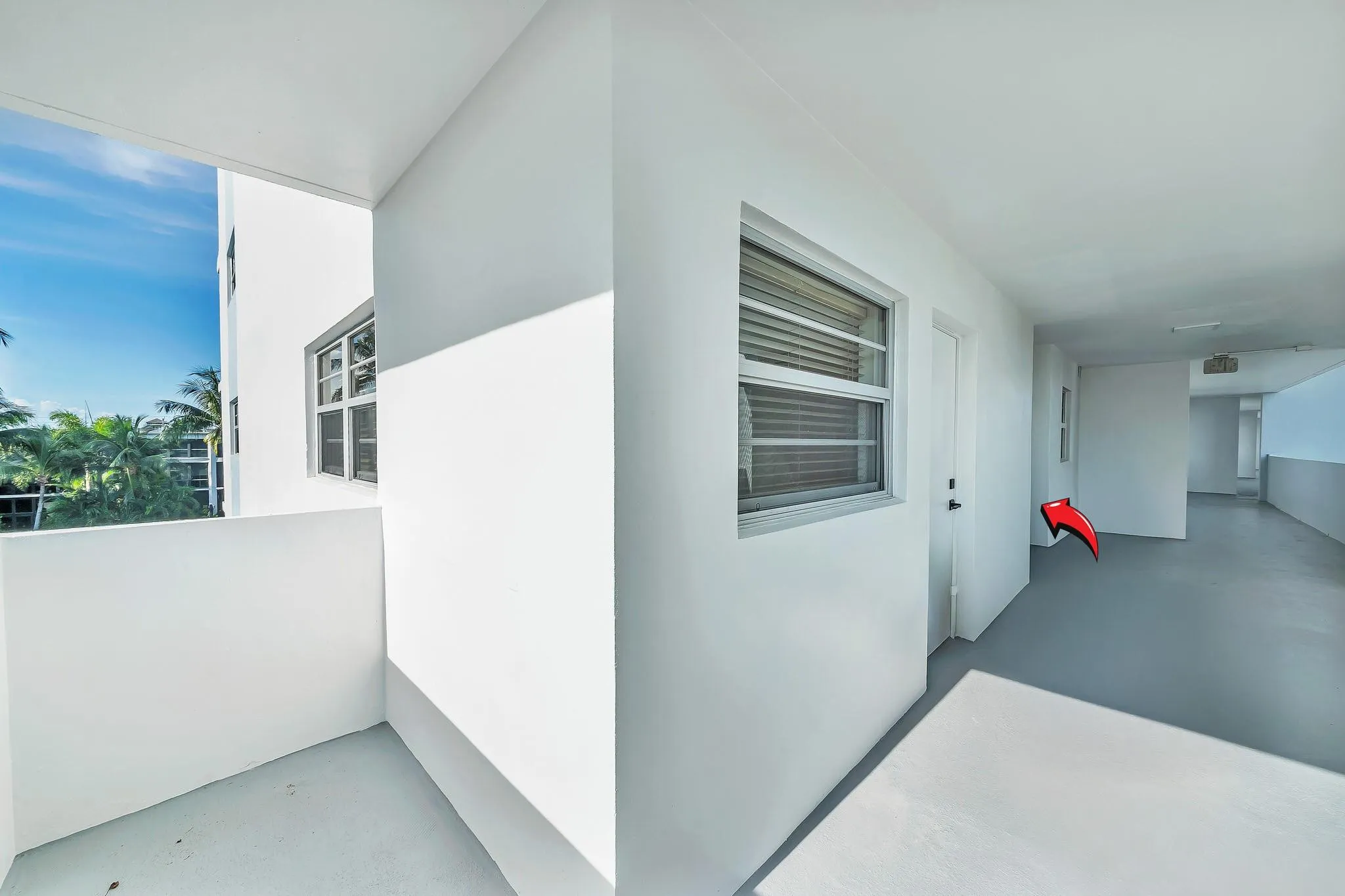 White exterior walls with multiple windows and a balcony