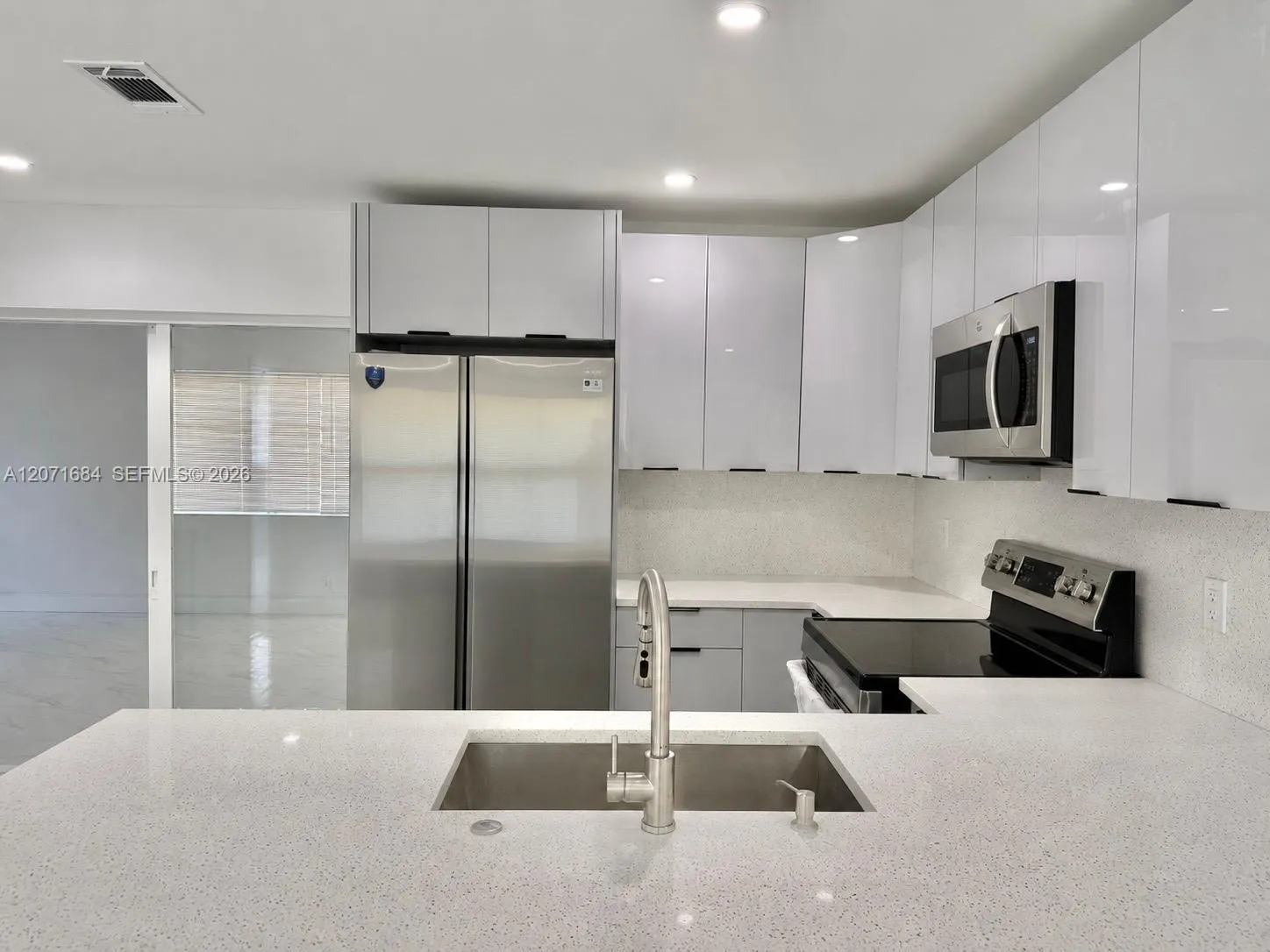 Modern kitchen with updated cabinetry and stone countertops. Digitally modified microwave added for illustration