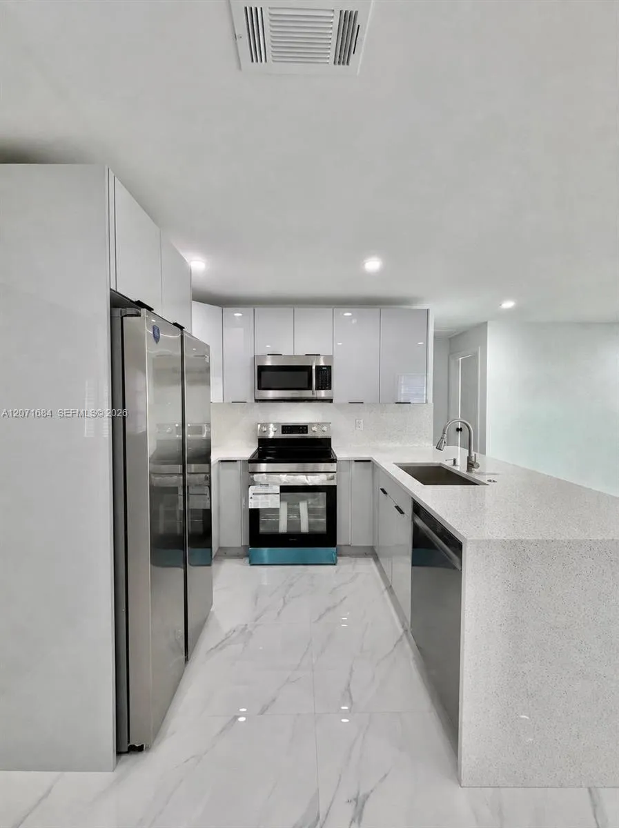 Open kitchen with stainless-steel appliances. Digitally modified microwave added for illustration