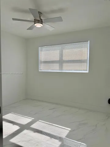 Second bedroom with tile flooring, ceiling fan and natural light