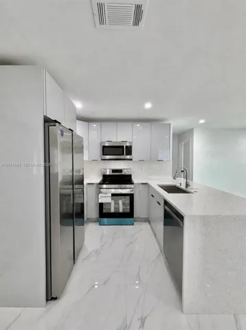 Open kitchen with stainless-steel appliances. Digitally modified microwave added for illustration