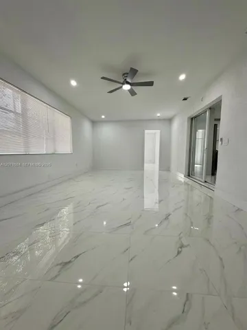 Spacious family room shown from another angle with tile flooring and natural light