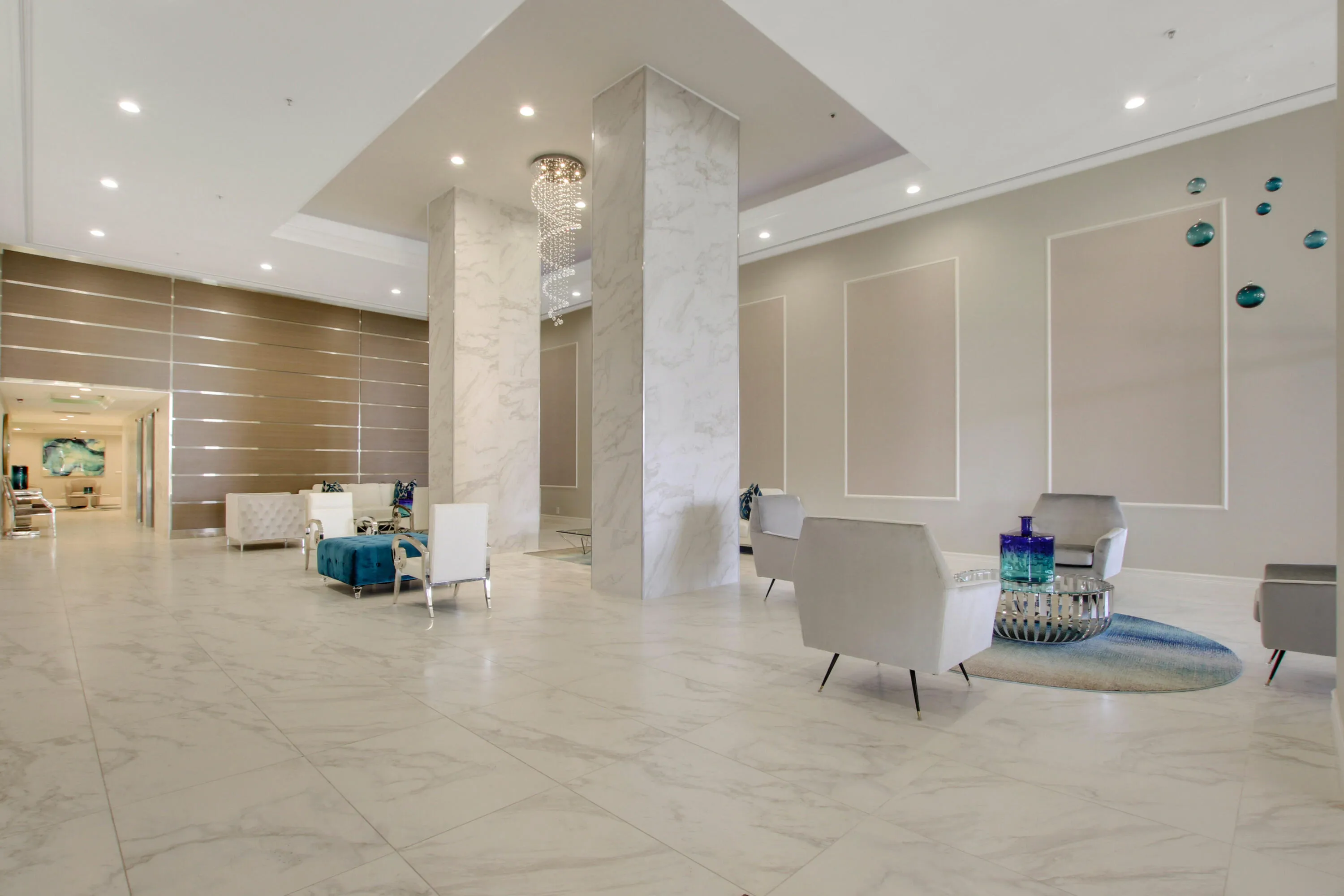 Spacious entryway featuring large format tile flooring, recessed lighting, decorative wall panels, and a tiered chandelier