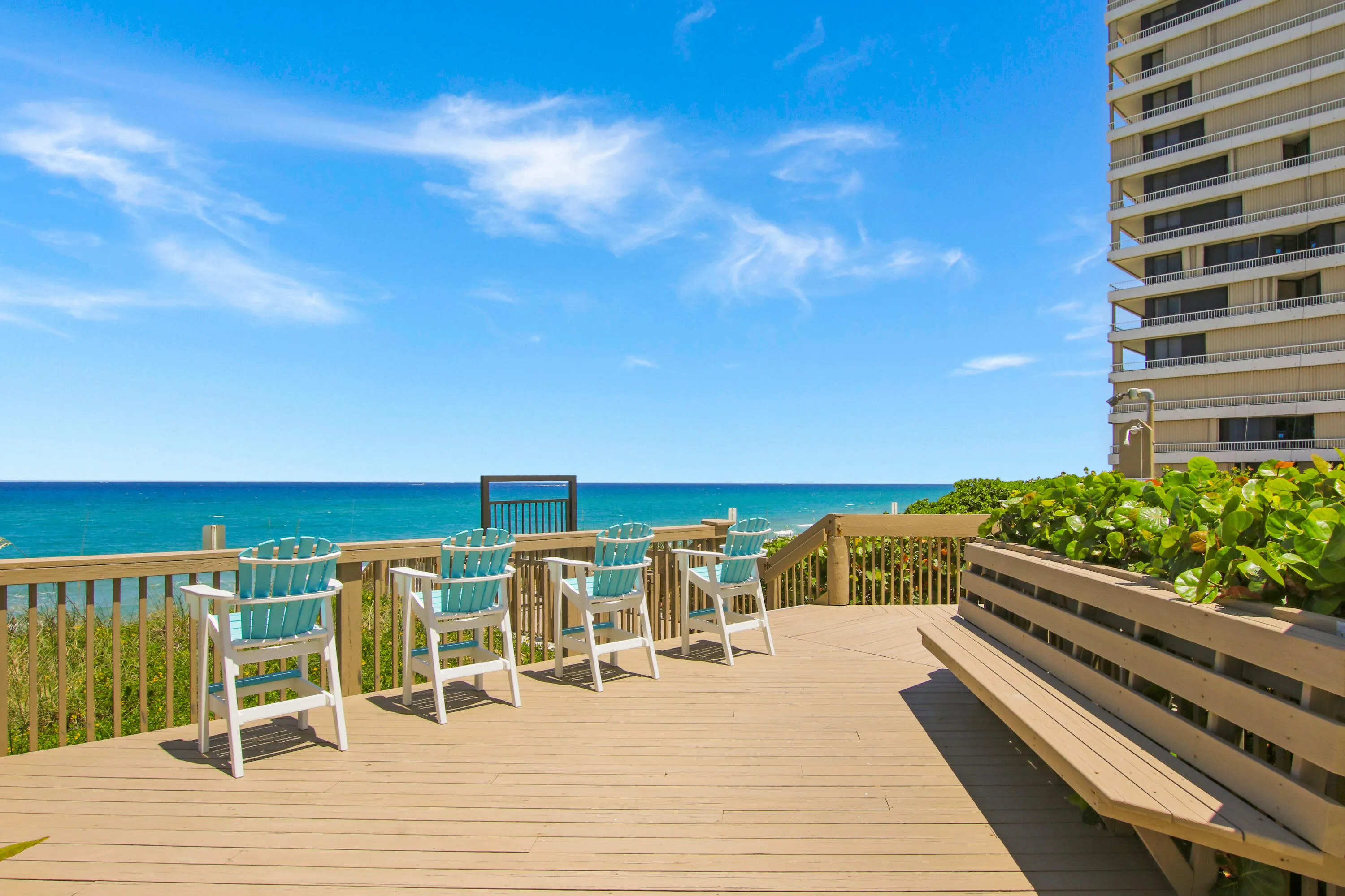 Expansive outdoor deck with wood-finish flooring, a built-in bench, and a privacy wall