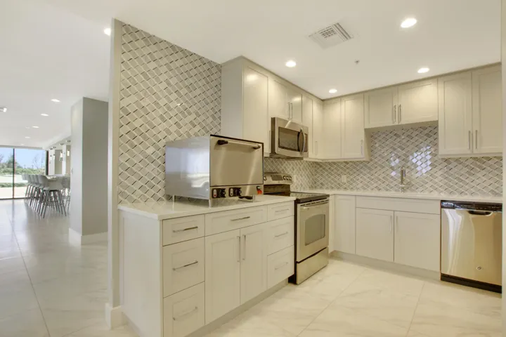 Kitchen featuring light cabinetry, stainless steel appliances, a tiled backsplash, recessed lighting, and tile flooring