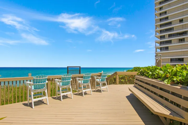 Expansive outdoor deck with wood-finish flooring, a built-in bench, and a privacy wall
