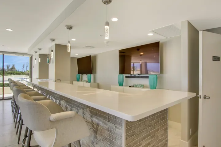 Extended bar with a light-toned countertop and a brick-patterned base