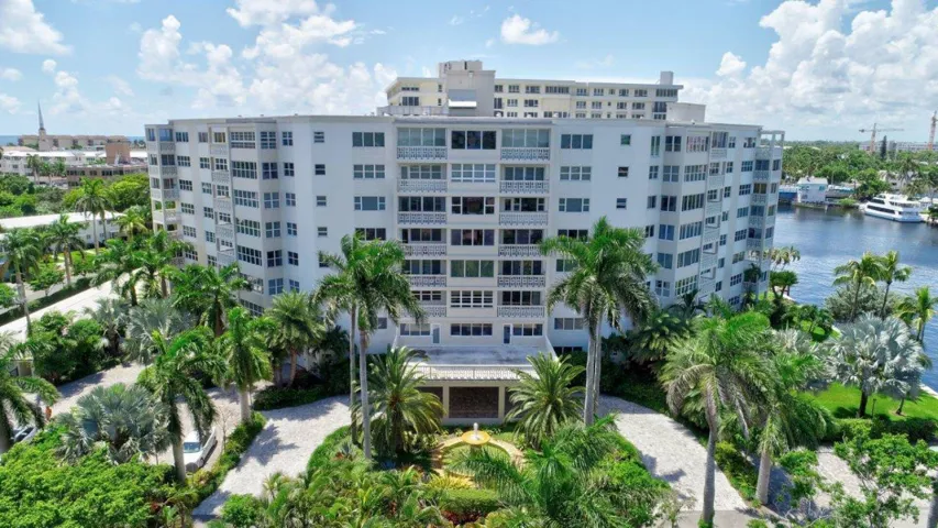 Multi-story residential building with private balconies and tropical landscaping