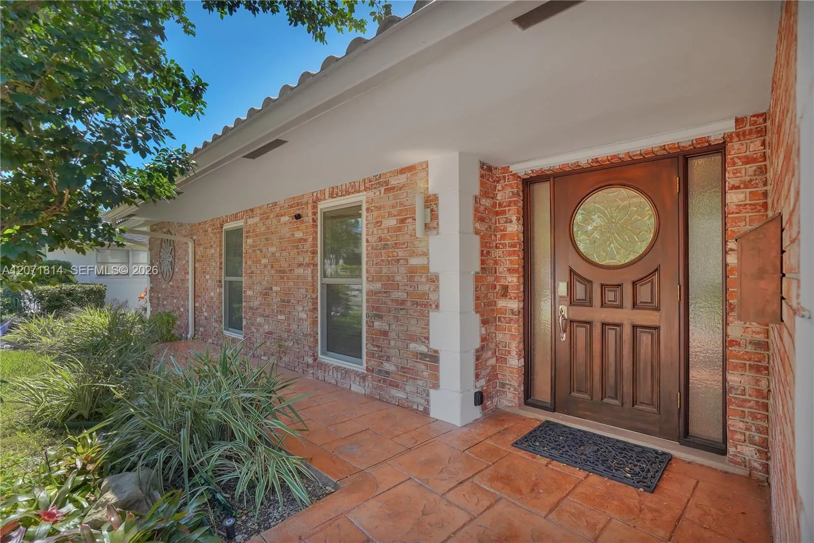 Classic front entrance featuring a decorative wood door and brick accents