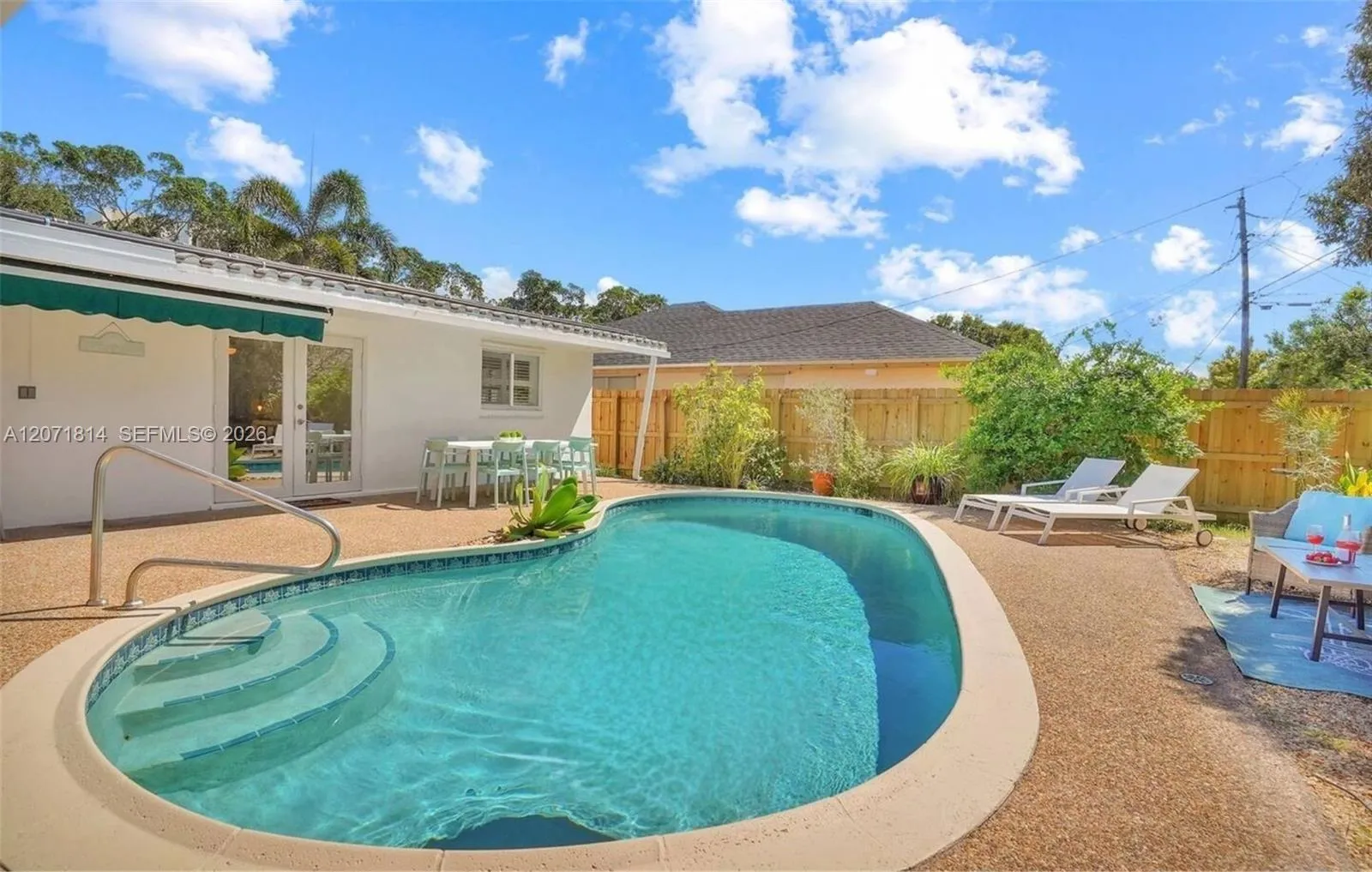 Tranquil poolside retreat with a covered lounge area for year-round relaxation