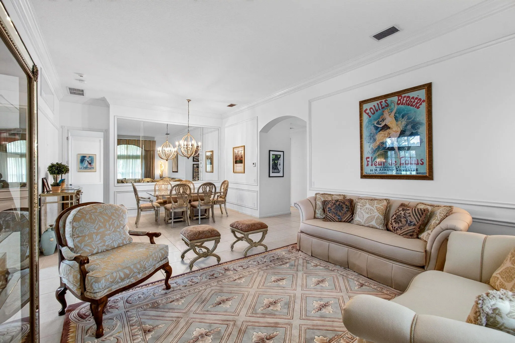 Open-concept living area with tile flooring and decorative wall molding