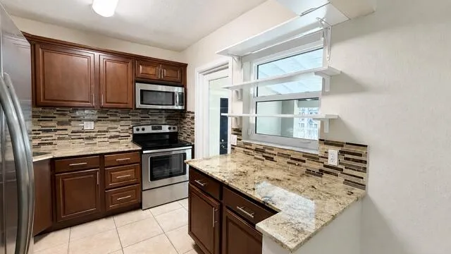 Bright, sun-filled kitchen ready for its next chef, with direct access to the outdoor living area