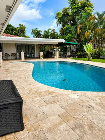 Spacious backyard with covered patio, pool and relaxing canal view.