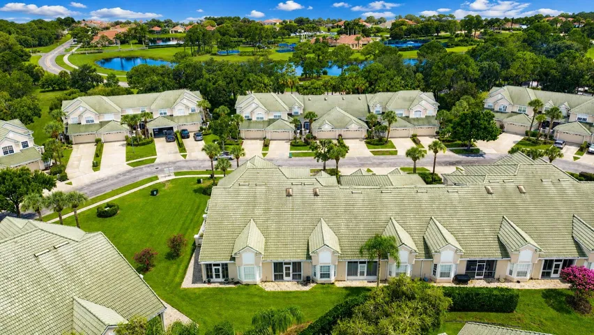 Community setting with tiled roofs, lush landscaping, and water features
