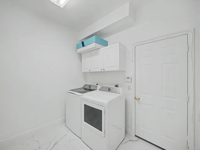 Laundry area featuring white cabinetry, white walls, and white flooring