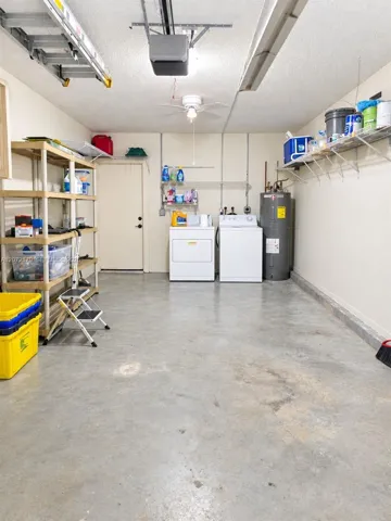 One car garage with a rear door and a door to kitchen