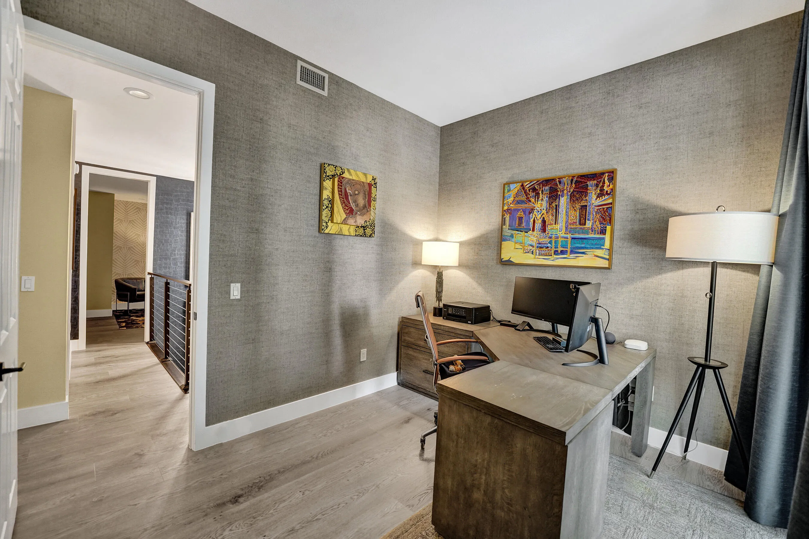Neutral-toned walls with textured finish, light wood-finish flooring, and white trim