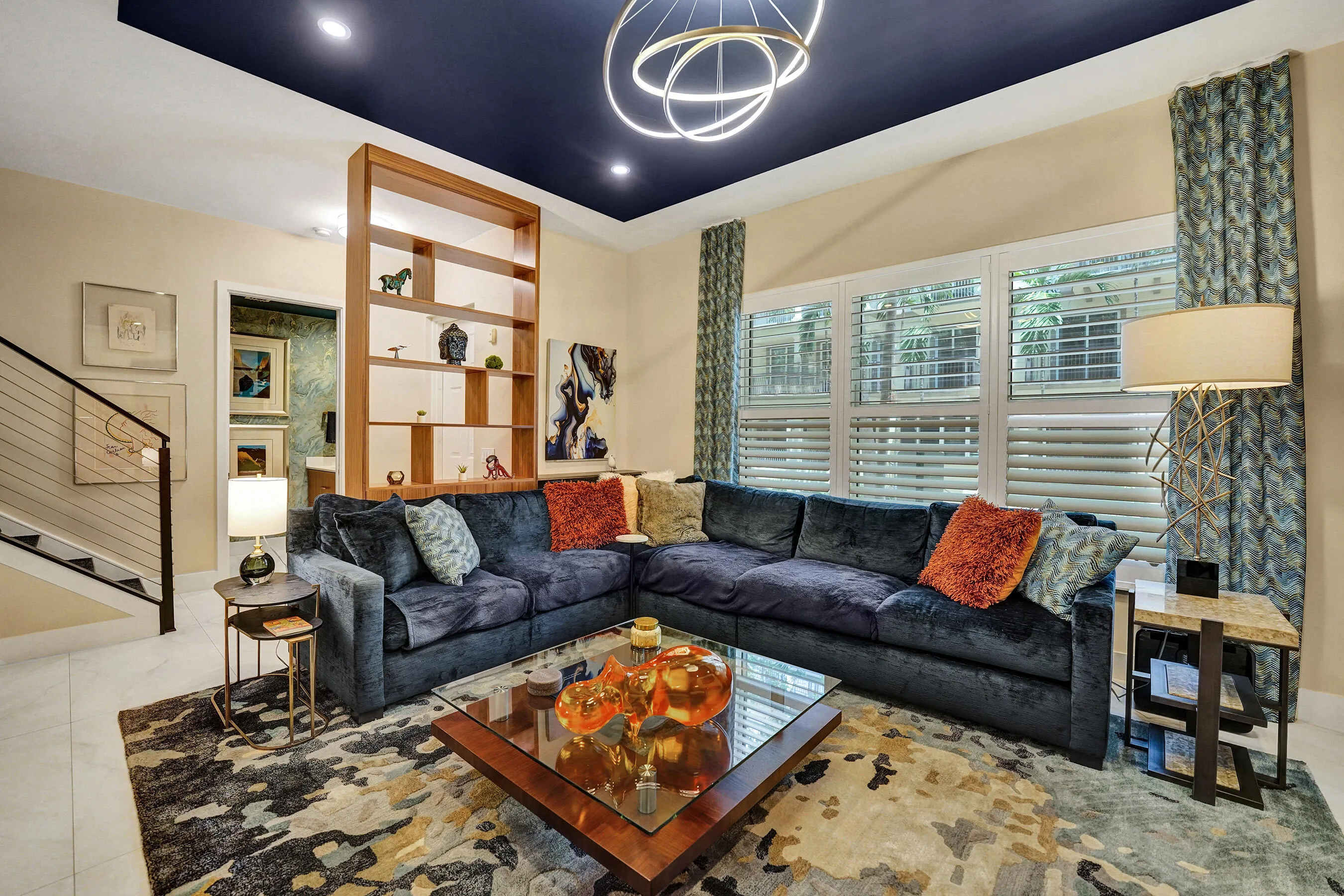 Recessed lighting and a decorative ceiling fixture illuminate a deep blue ceiling