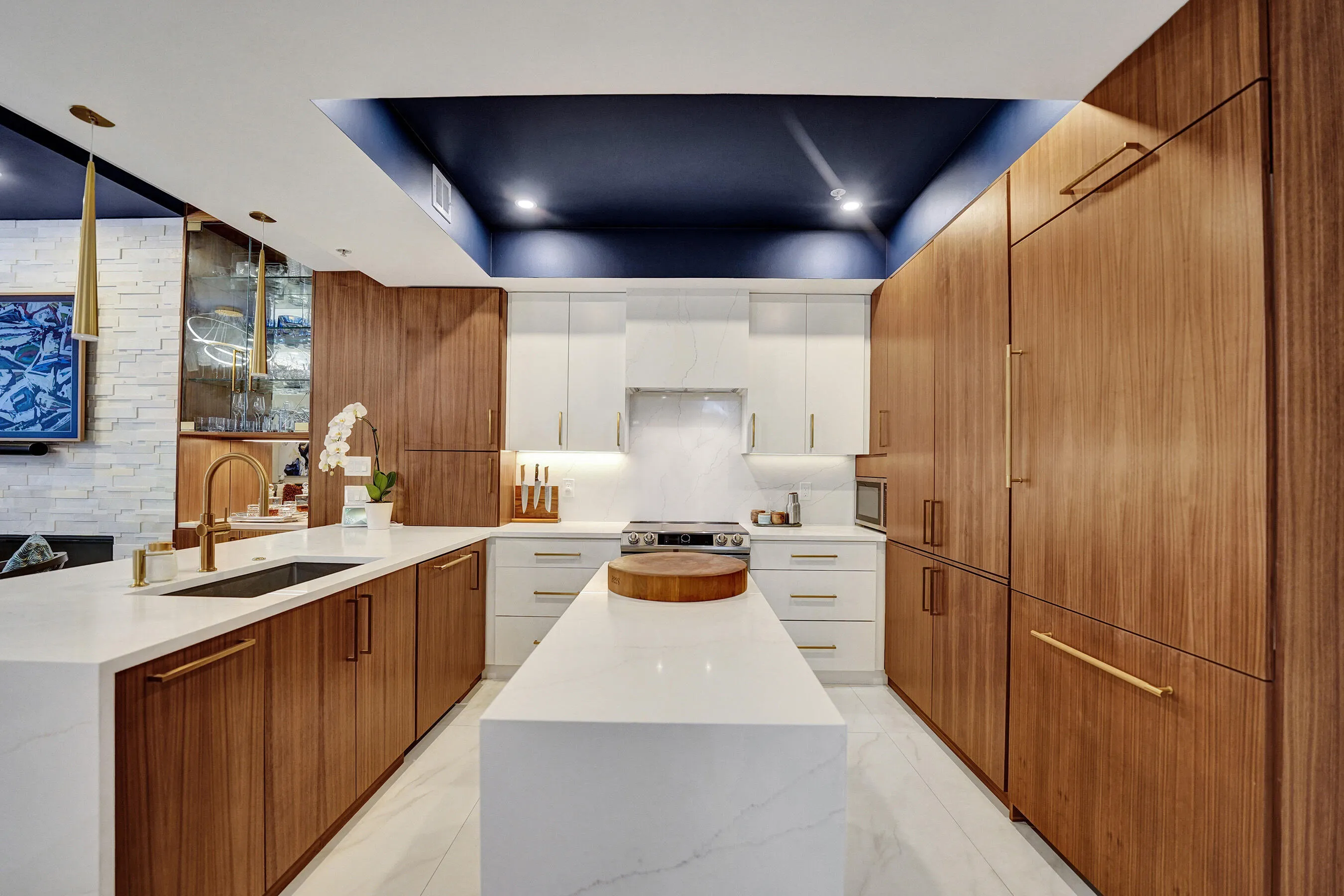 Contemporary kitchen featuring wood-finish cabinetry, white countertops, and a central island