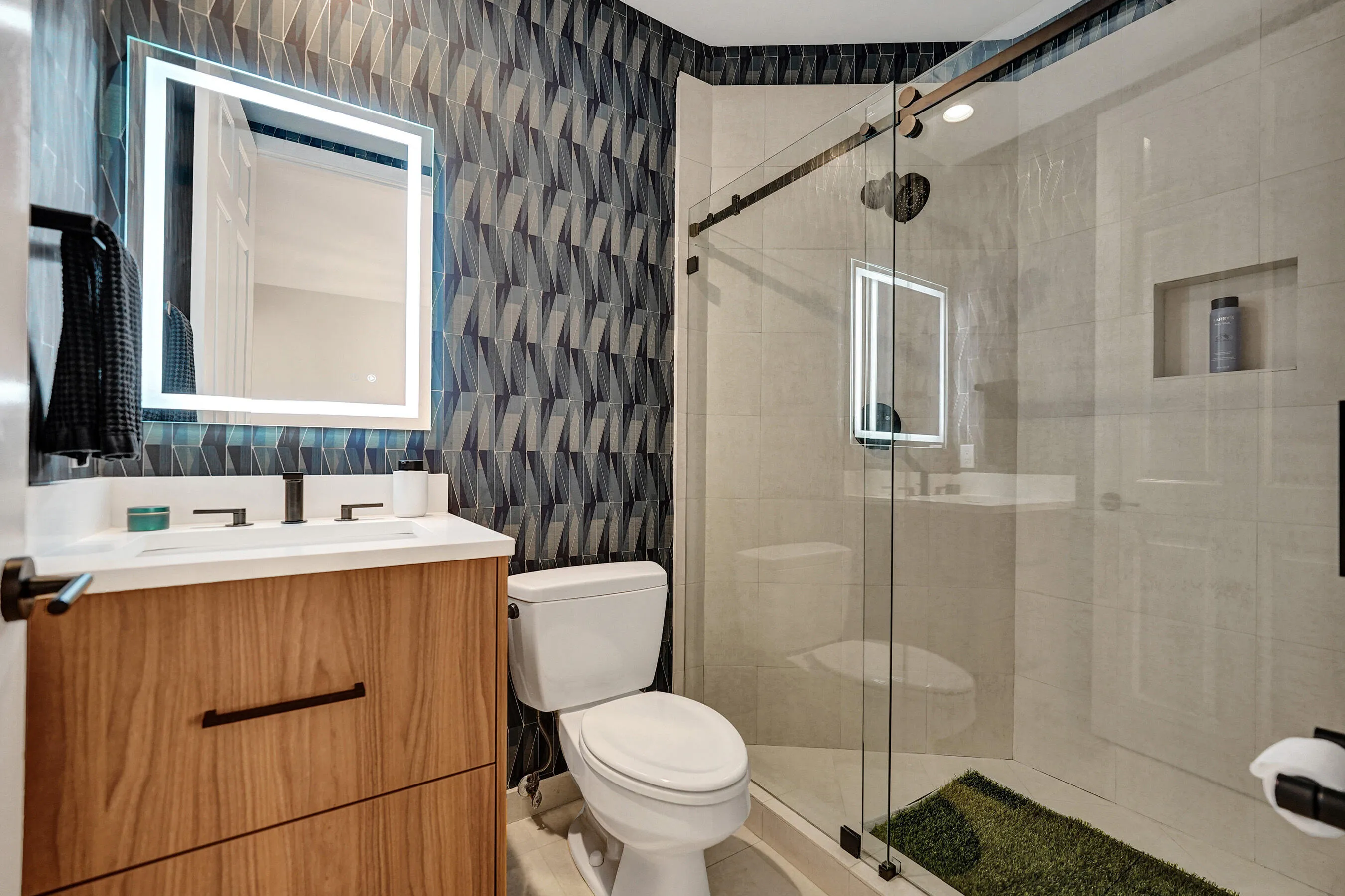 Wood-finish vanity with a white countertop and matte black fixtures