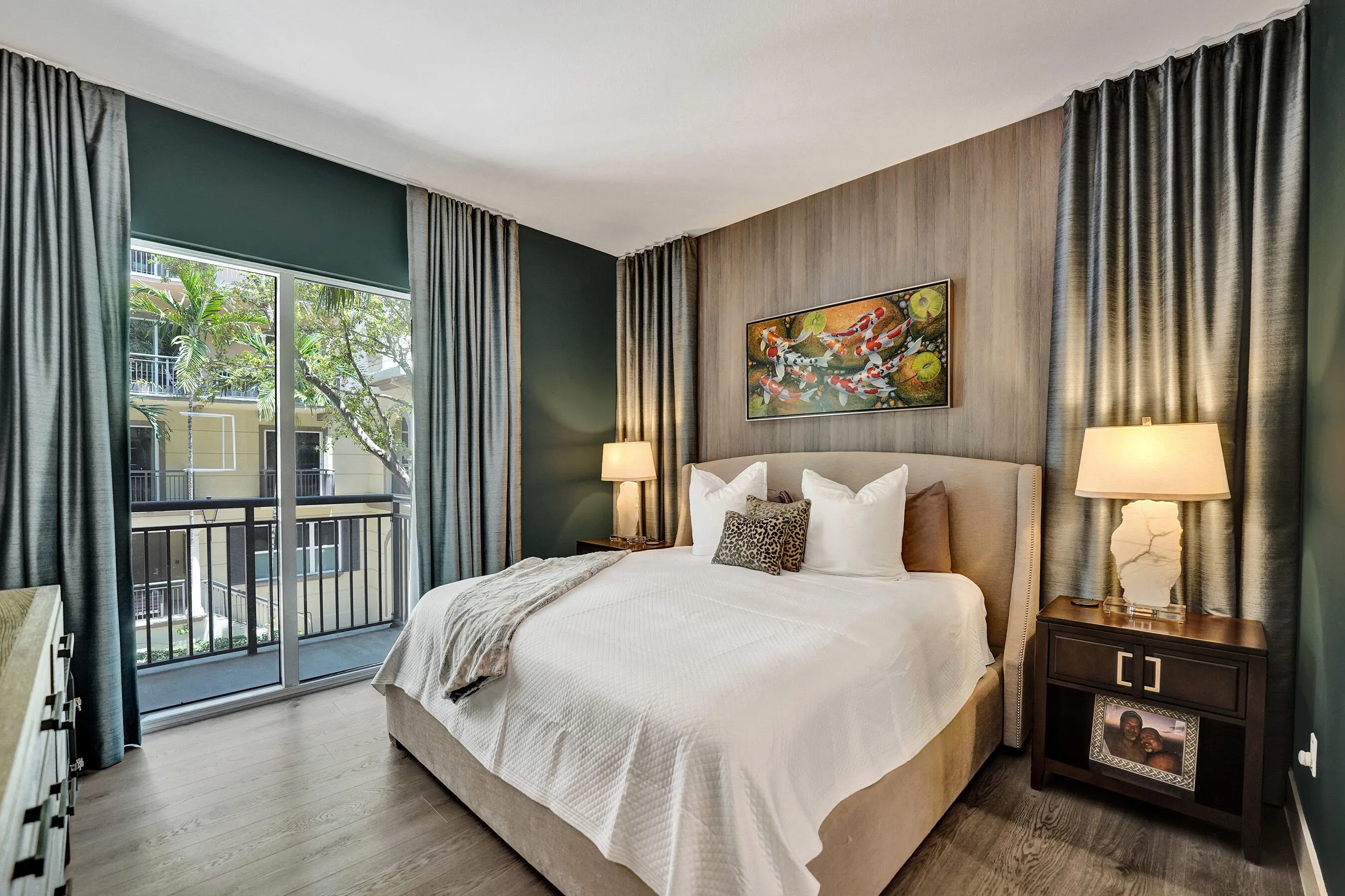 Full-height sliding glass doors with balcony access, wood-finish flooring, and a feature wall with vertical paneling