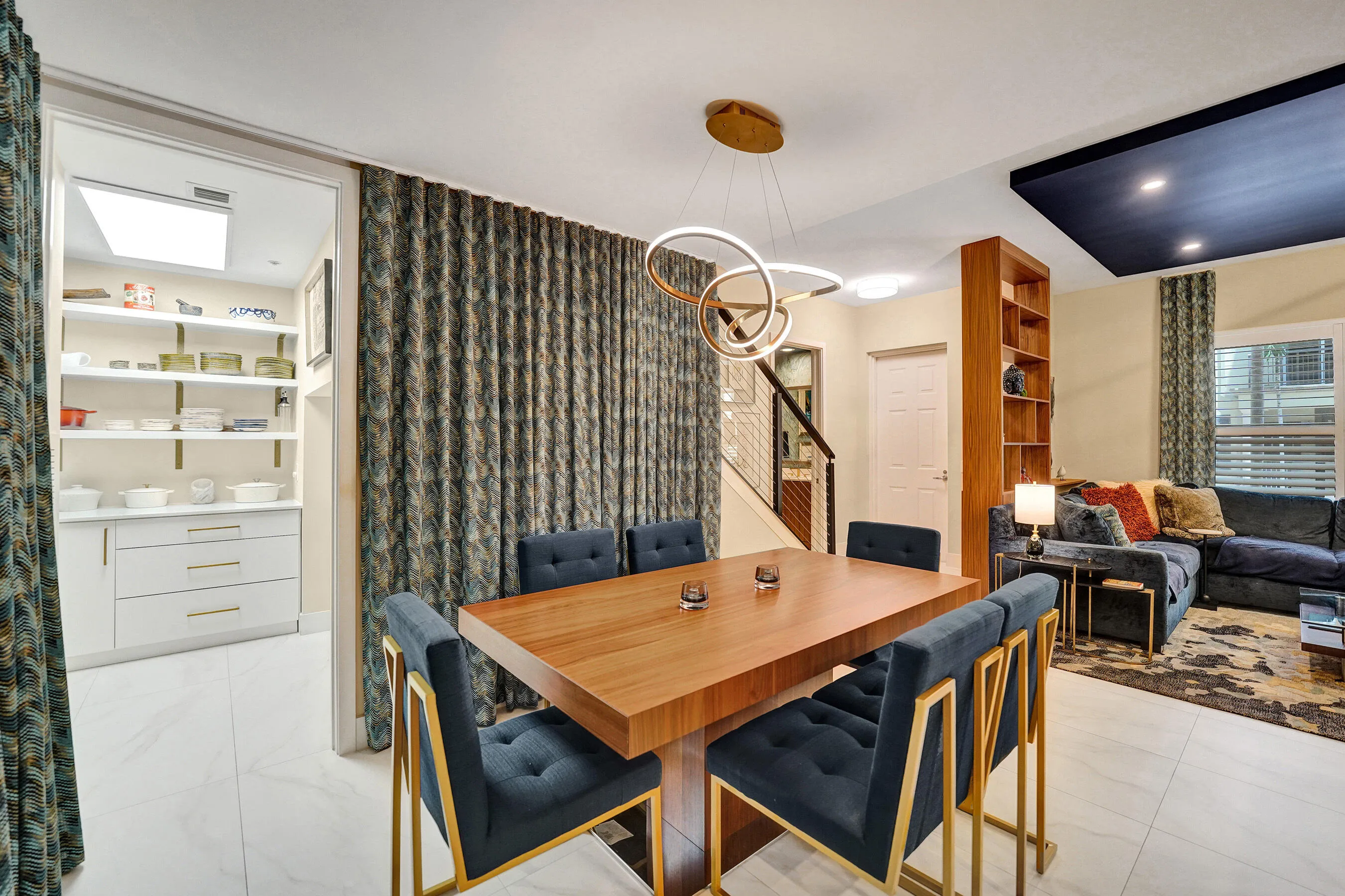 Dining area featuring a modern chandelier, wood-finish table, and tile flooring