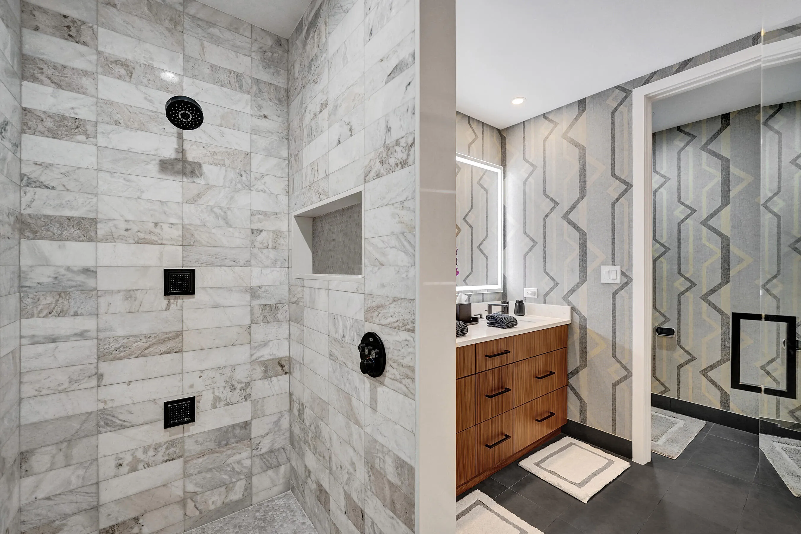 Tiled shower with matte black fixtures and a built-in niche