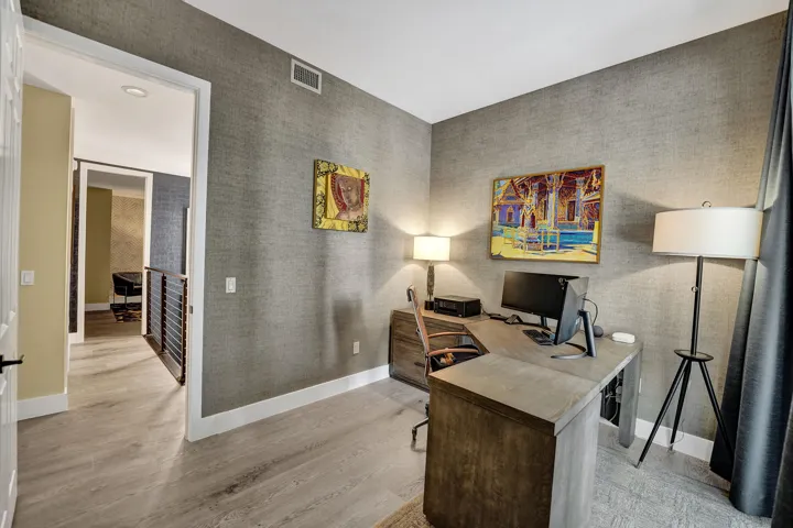 Neutral-toned walls with textured finish, light wood-finish flooring, and white trim