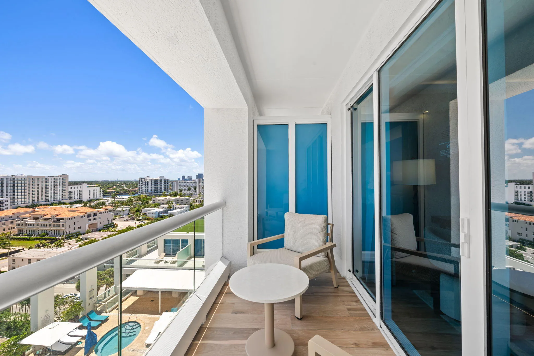 Balcony featuring wood-finish flooring, glass railing, and sliding glass doors