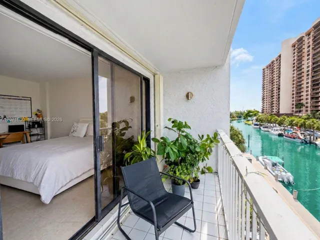Primary bedroom suite with seamless sliding-door access to the waterfront balcony.