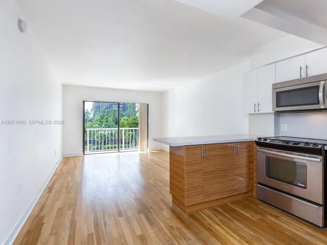 Modern open kitchen featuring stainless steel appliances, custom cabinetry, and a cozy breakfast bar.