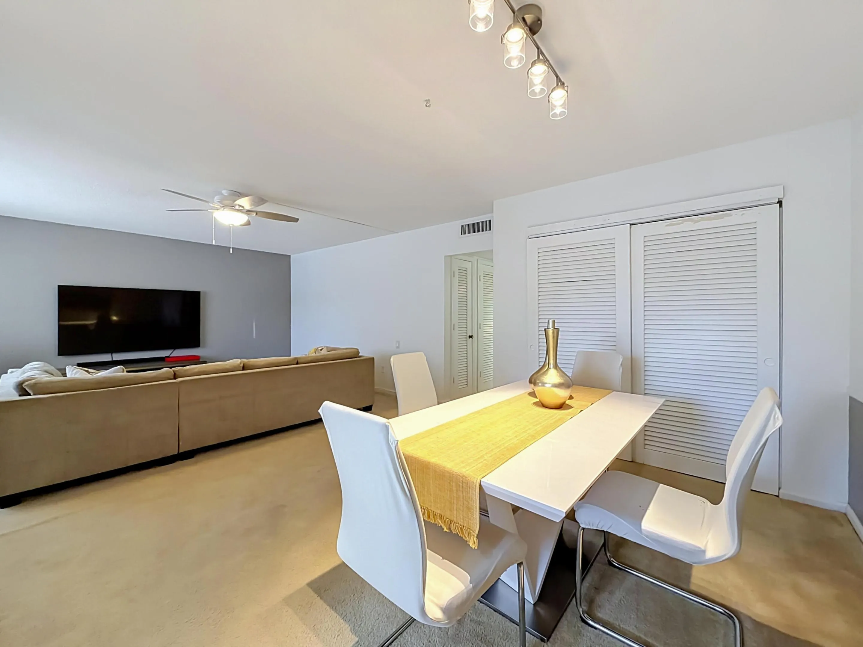 Recessed lighting, ceiling fan, white louvered sliding closet doors, and track lighting fixture