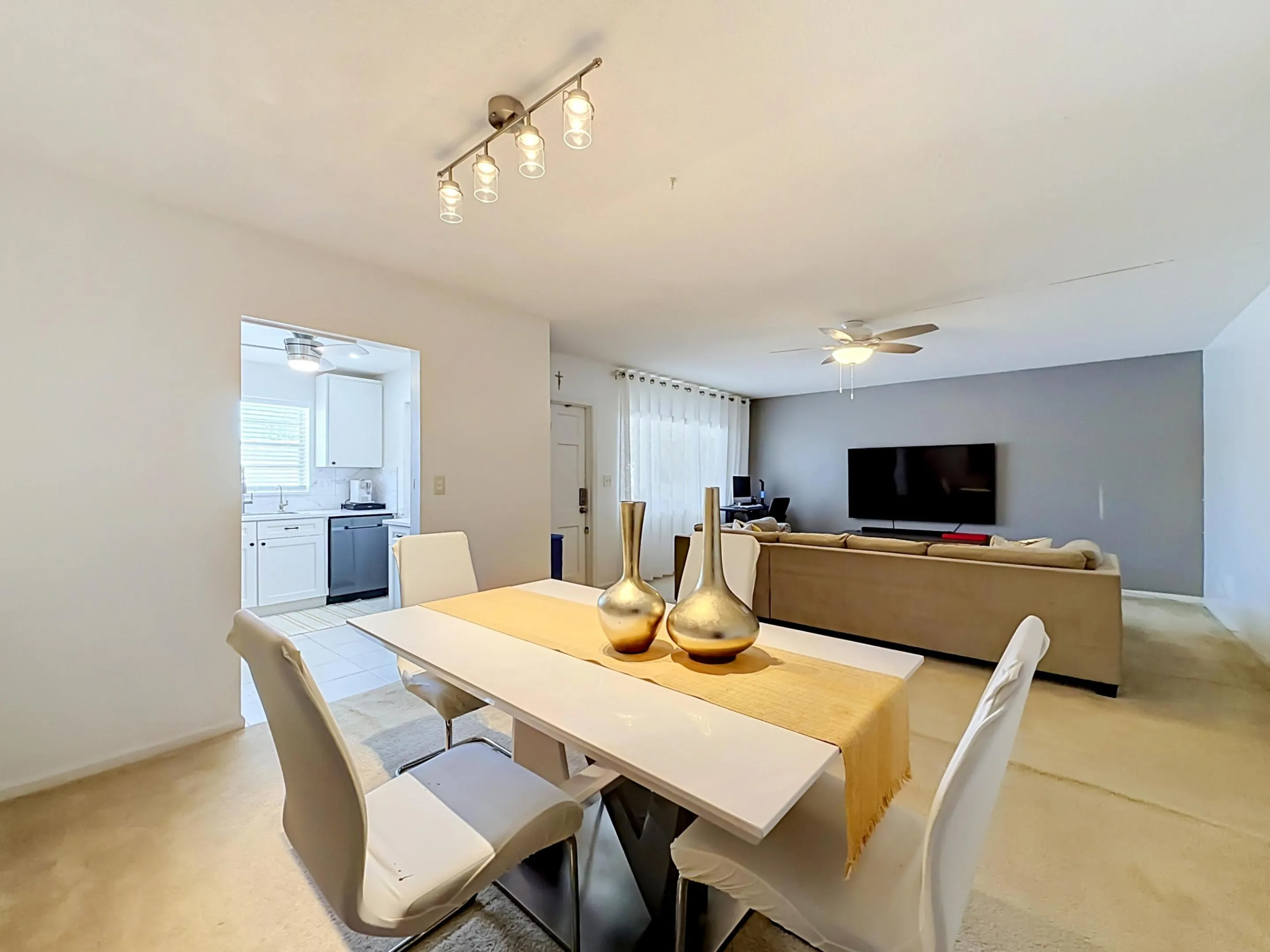 Recessed kitchen with white cabinetry and stainless steel dishwasher