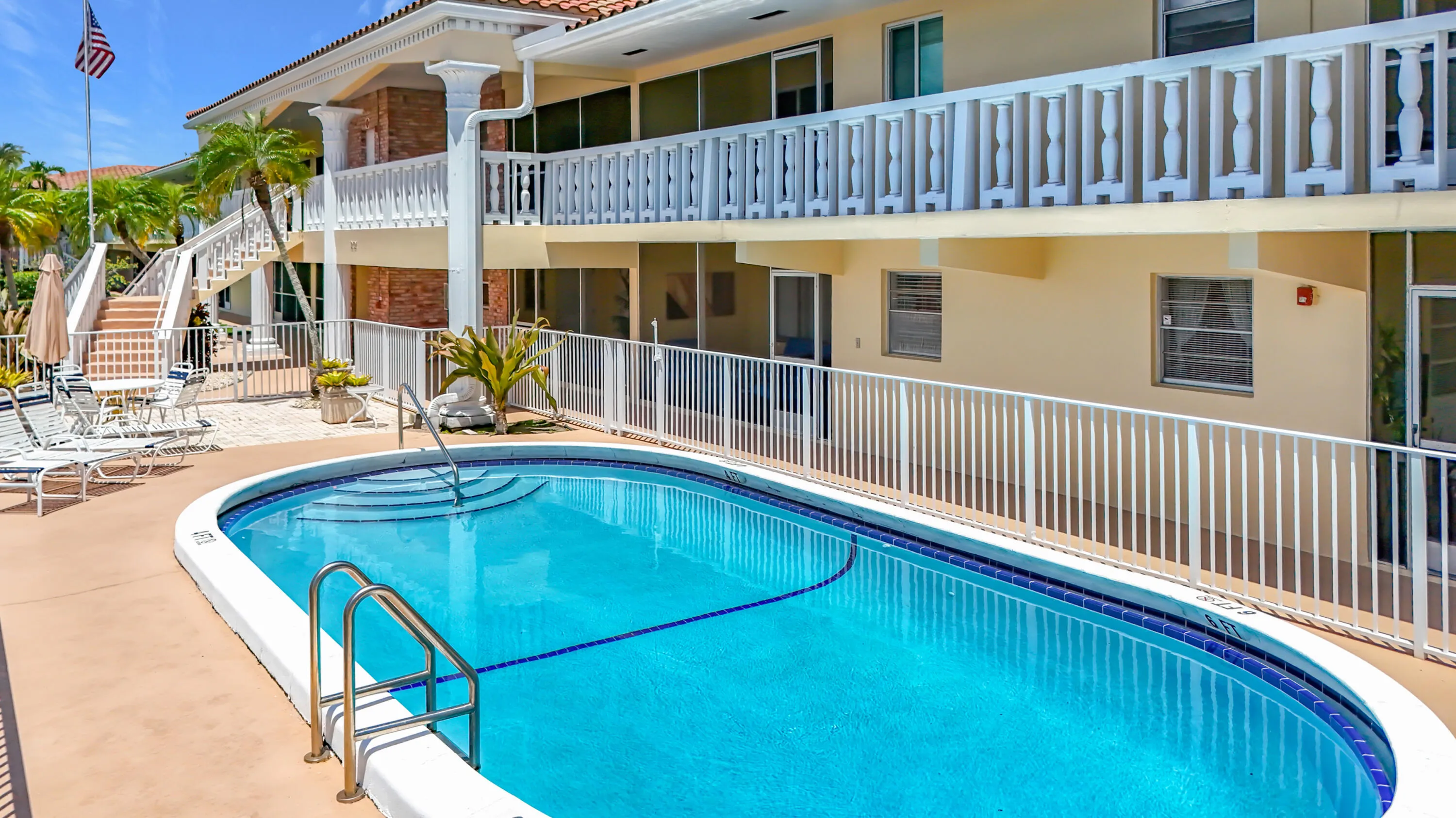 Oval-shaped pool with integrated steps and a surrounding paver deck
