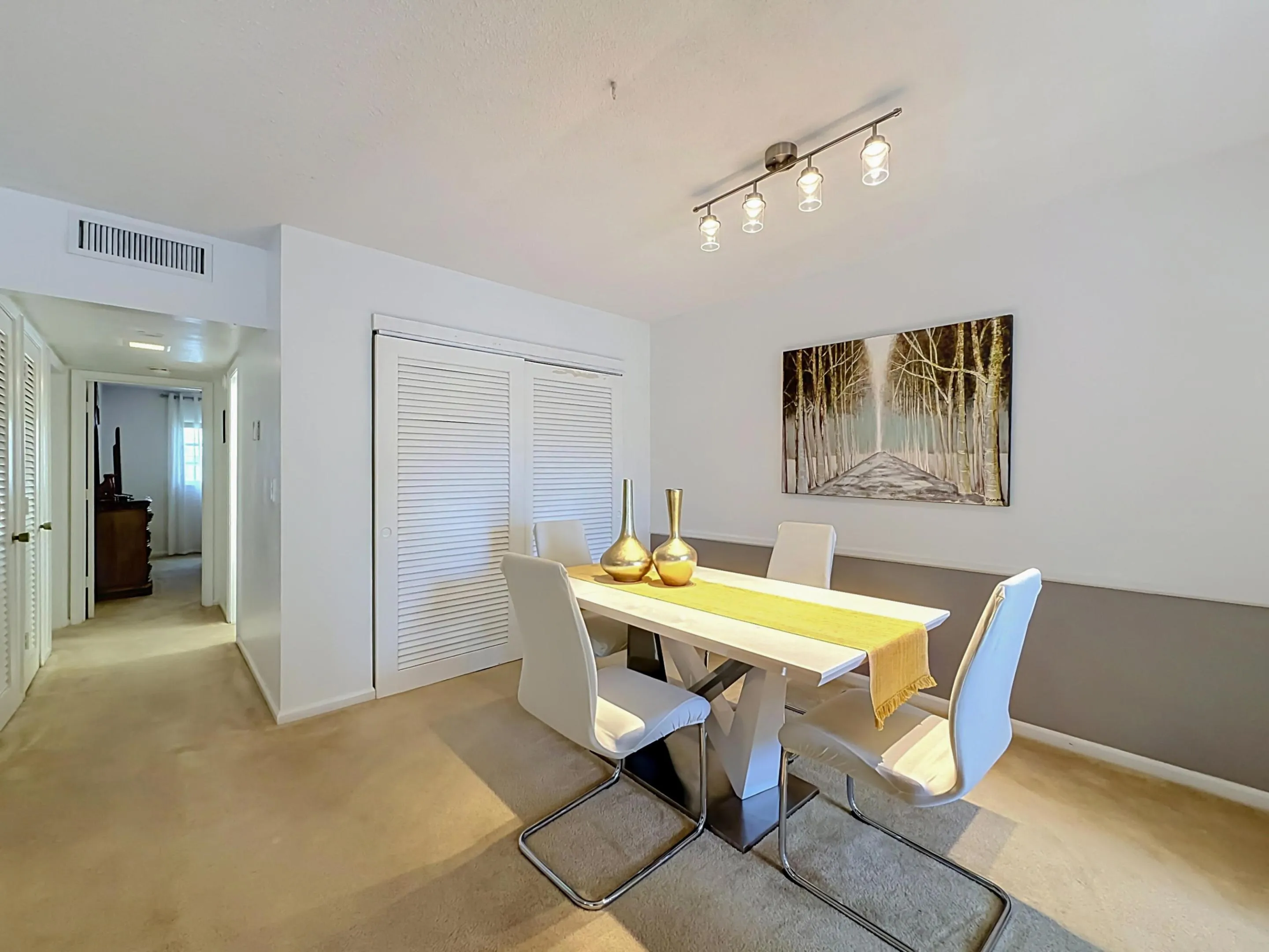 Recessed lighting fixture, light-colored carpeting, white louvered bifold closet doors, and painted walls