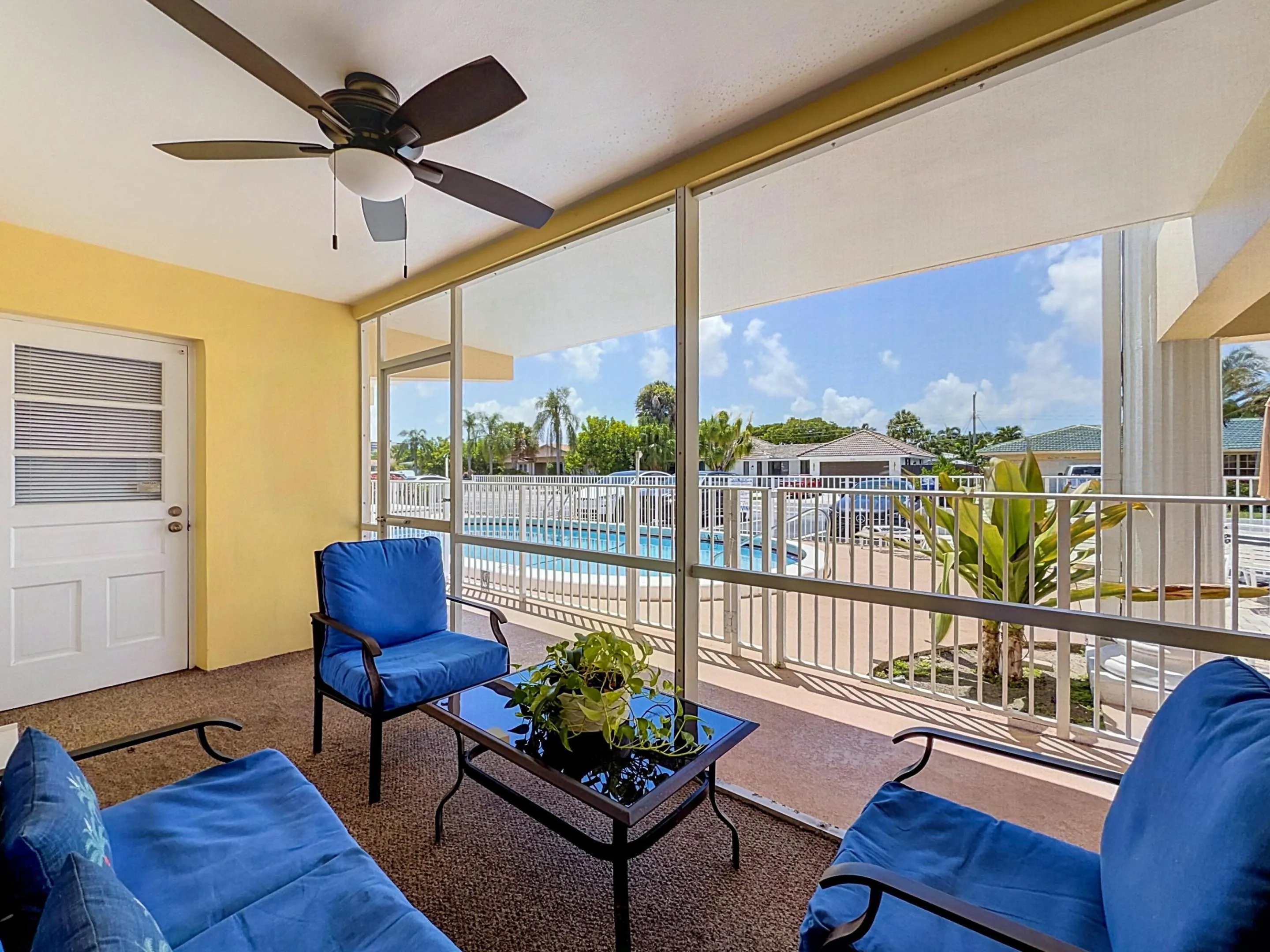 Screened-in patio with a ceiling fan and textured flooring