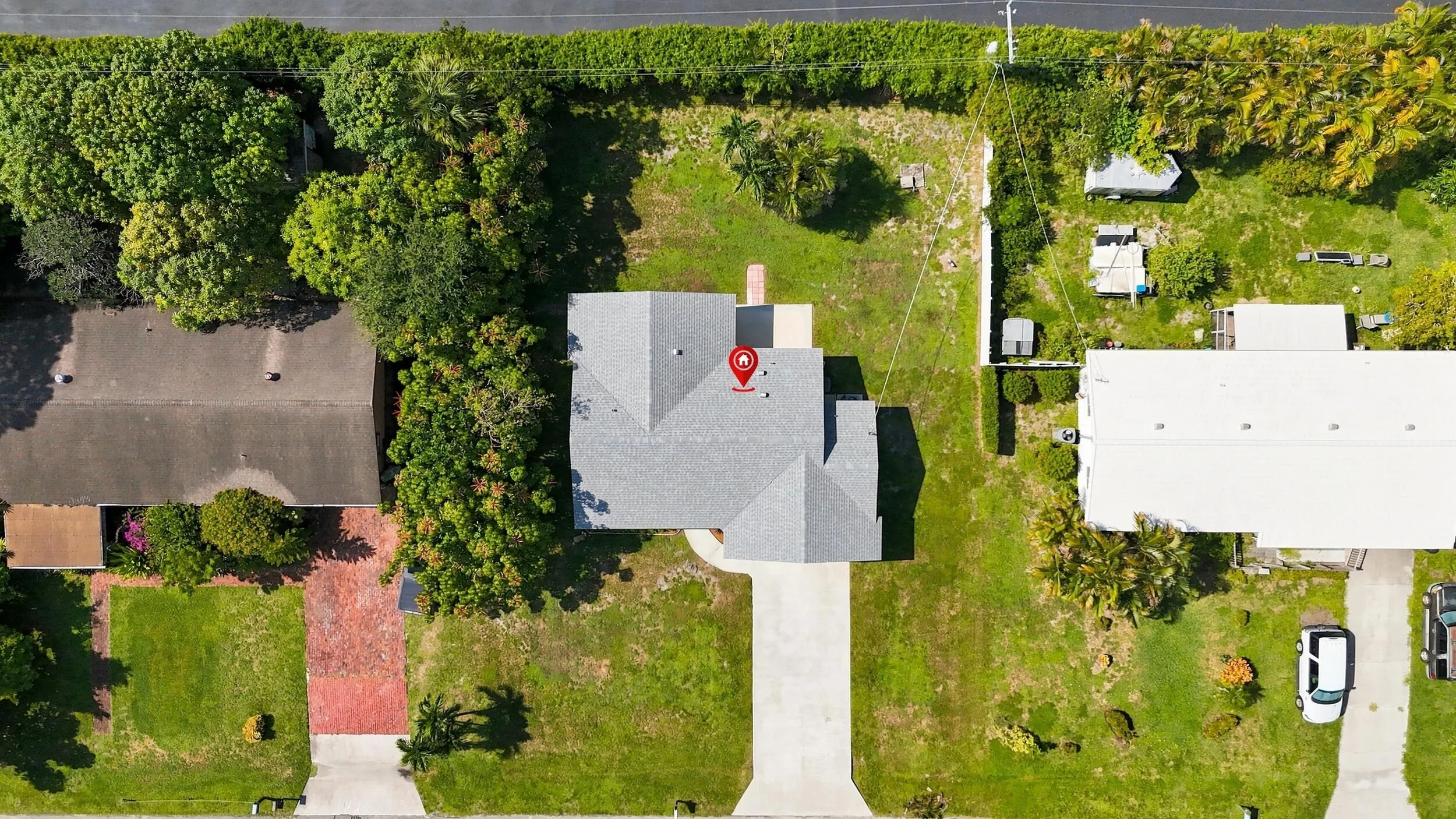 Overhead aerial view showcasing the home, lot, driveway, and surrounding properties.