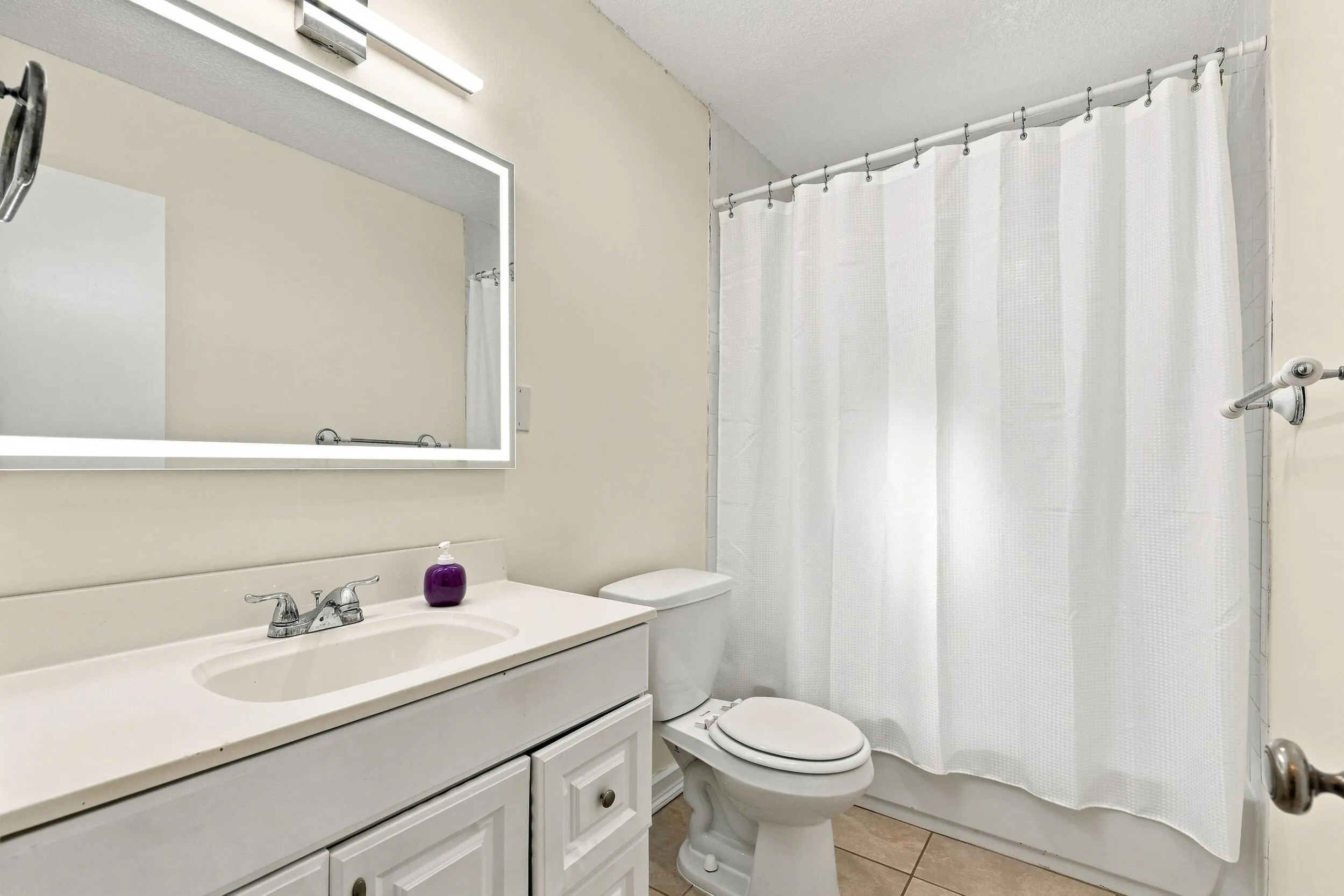 Full bathroom with vanity, tub and shower combination, and neutral finishes.