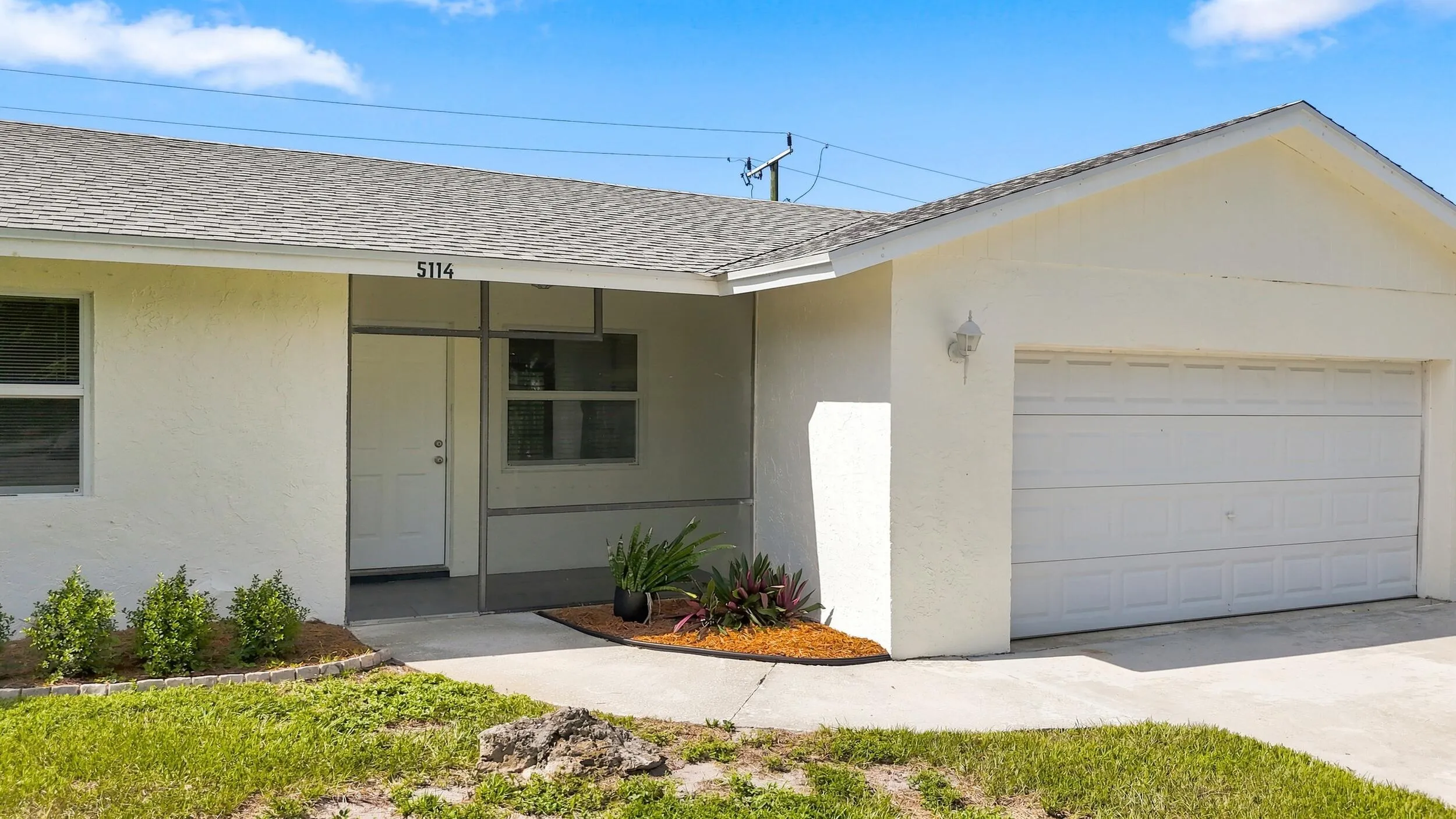 Welcoming front exterior featuring the covered entry and attached garage.