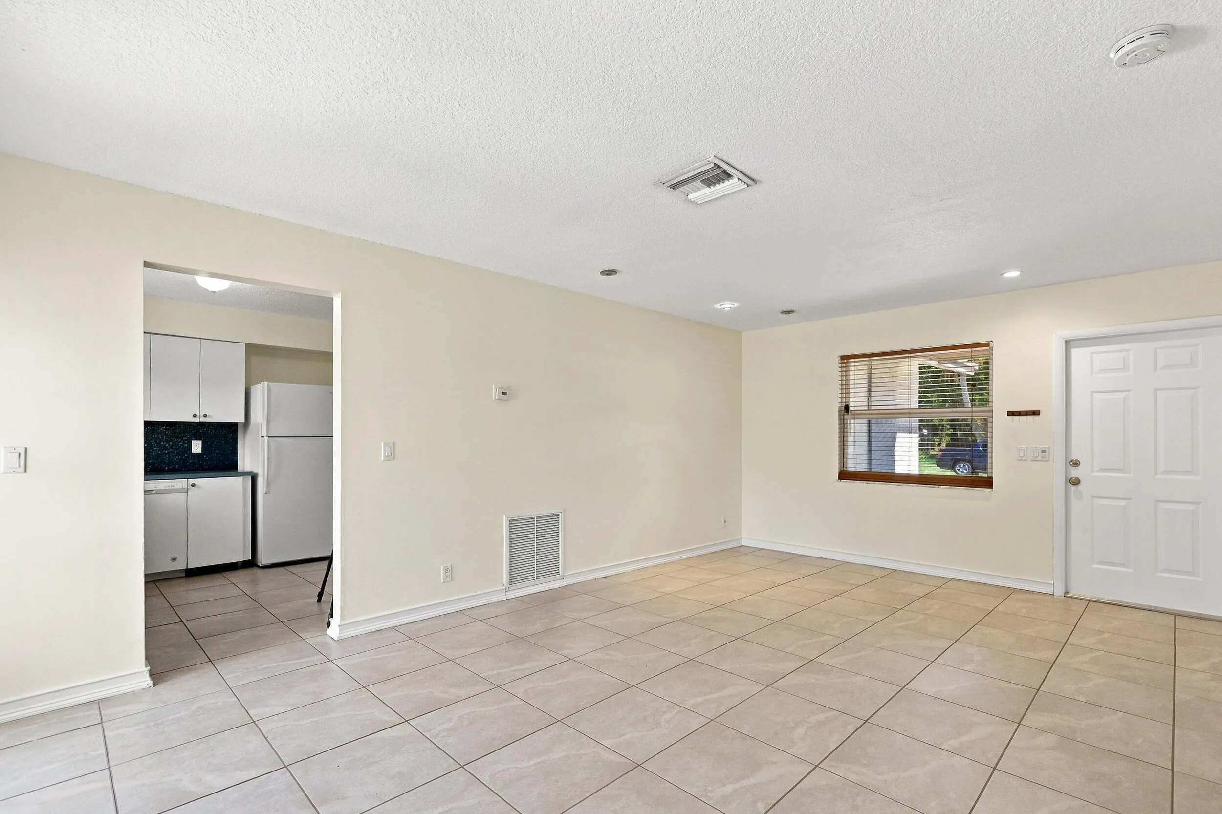 Open living area with tile flooring and convenient access to the kitchen.