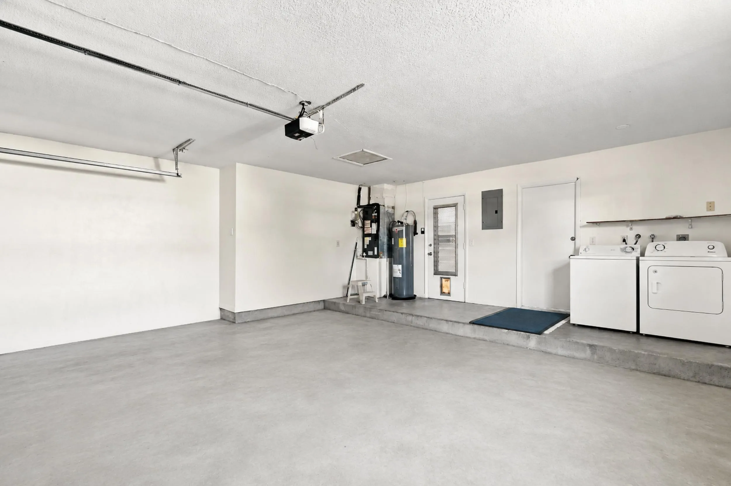 Spacious garage with utility area and room for parking and storage.