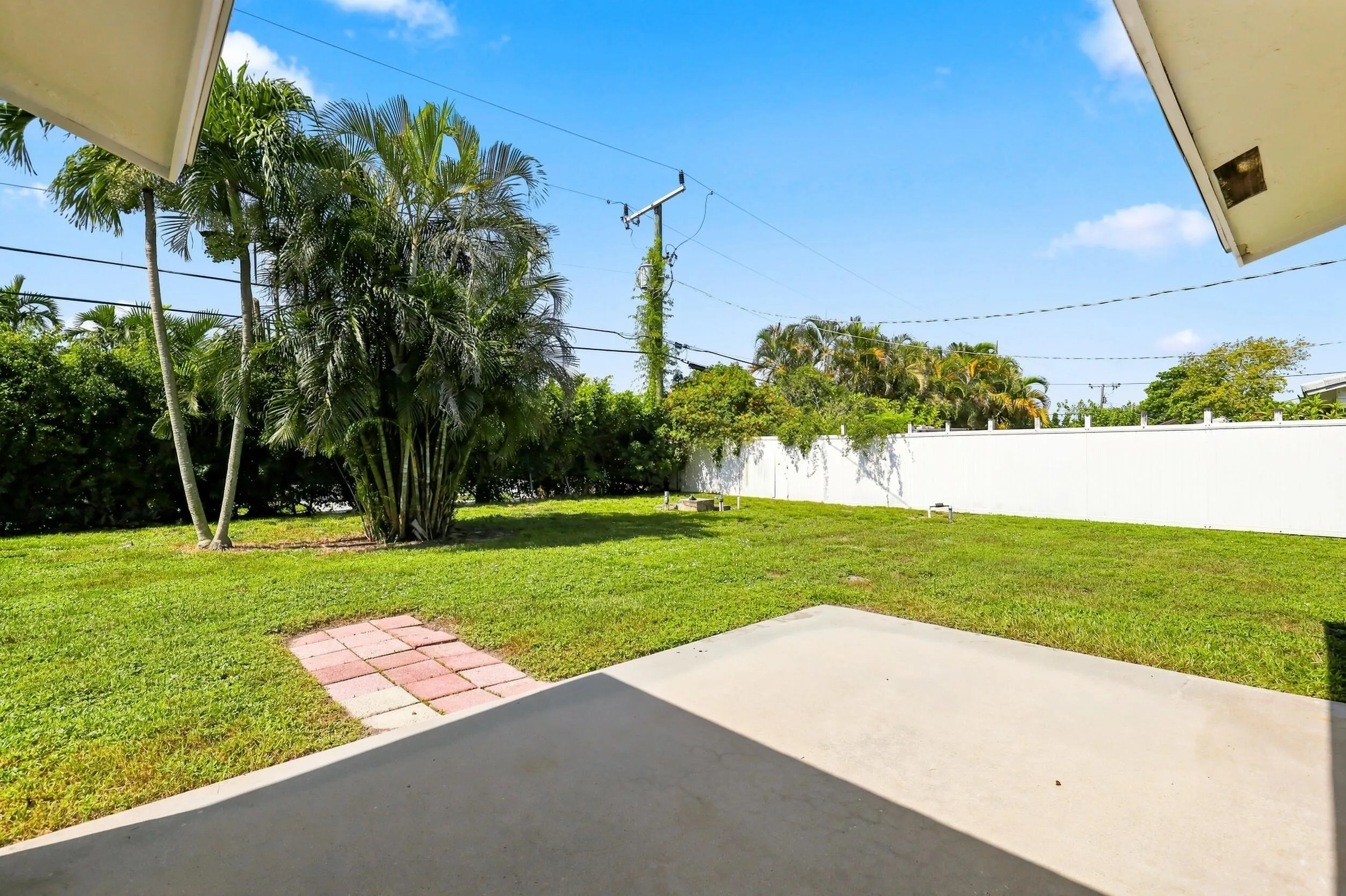 Spacious backyard with patio area, mature landscaping, and plenty of open lawn.